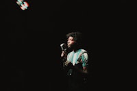 a man with dreadlocks singing into a microphone