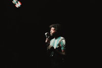 a man with dreadlocks singing into a microphone